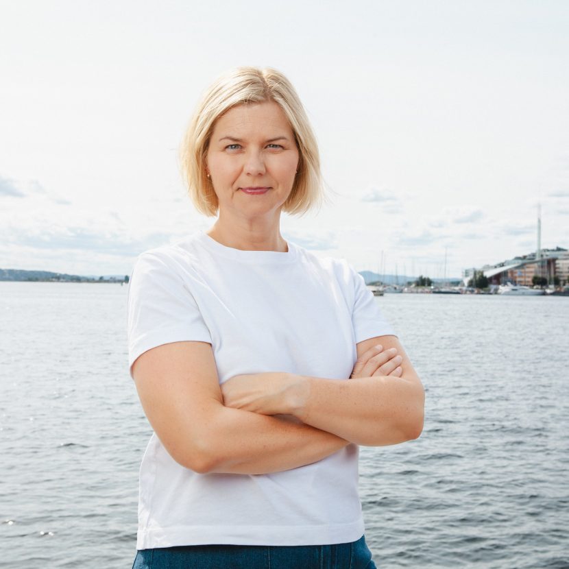 Guri Melby ved Oslofjorden. Med armene i kors med et alvorlig blikk i kamera.