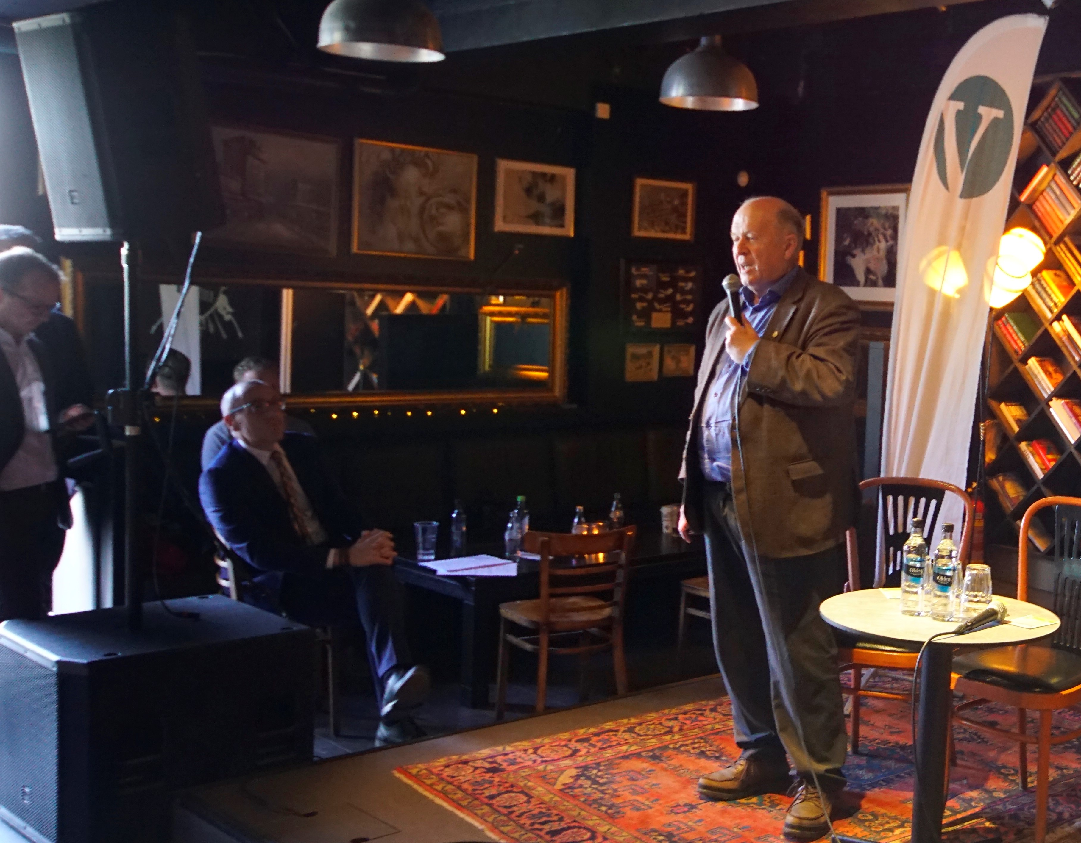 BIlde av Odd Einar Dørum mens han holder sitt åpningsinnlegg på scenen. Flott Venstreflagg bak og ordfører Tom Staahle ser beundrende på.