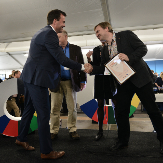 Ordførar iAlfred Bjørlo blir gratulert av leiar i Zero Marius Holm og jurymedlem Odd Einar Dørum