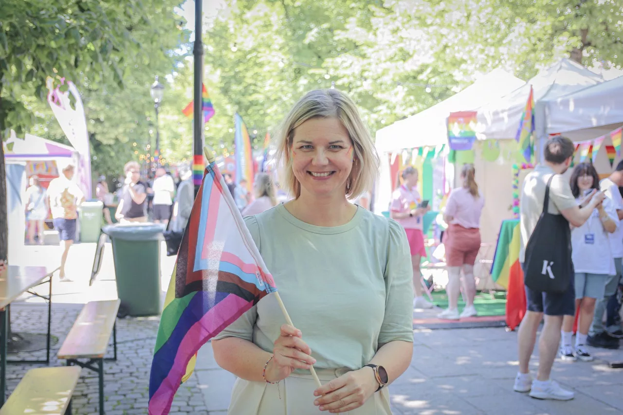Guri Melby smiler og holder et Pride-flagg under en markering i Oslo – et symbol på Venstres kamp for likestilling og mangfold.