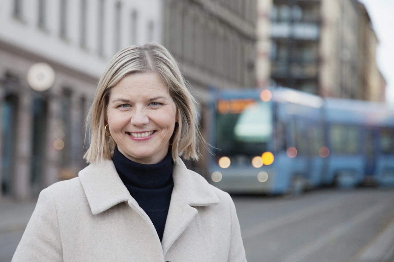Guri Melby i byen med trikk i bakgrunnen