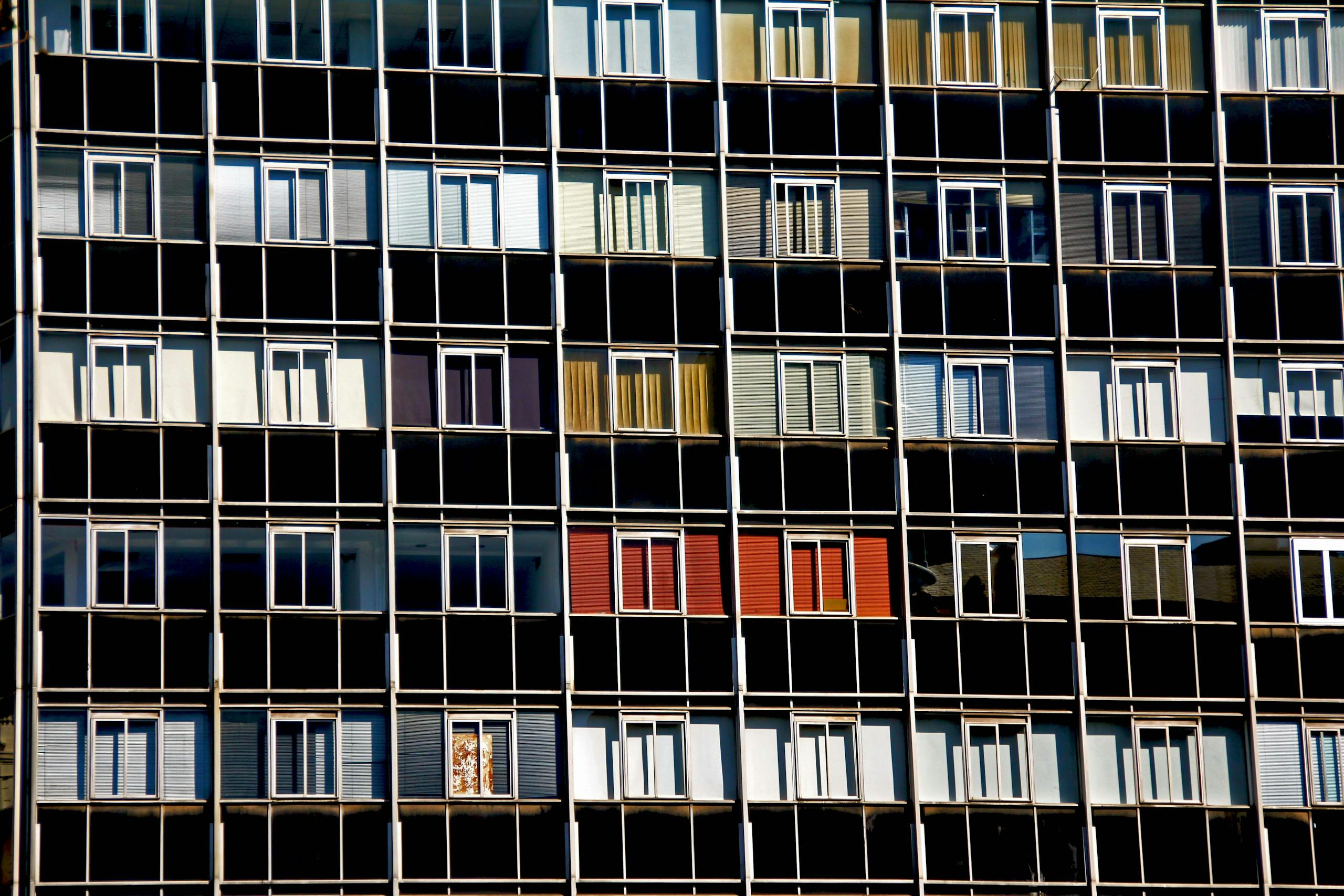 A vibrant facade of a modern apartment building with varied window colors and patterns.