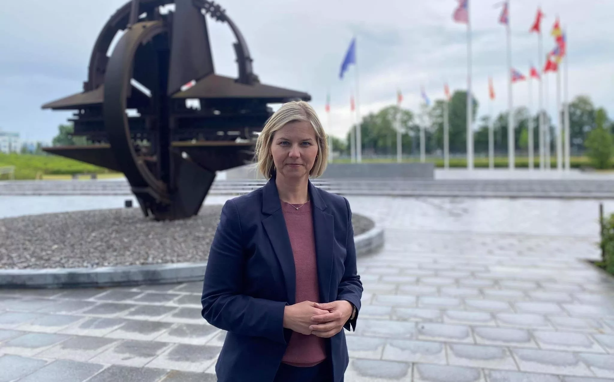 Bilde av Guri melby utenfor Natos hovedkvarter i Brussel. Natosymbolet som skulptur i bakgrunnen.