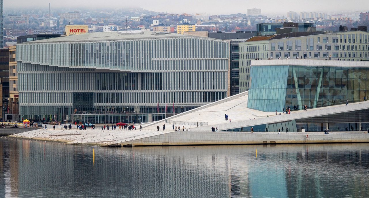 Bybilde av Oslo med moderne arkitektur, der kulturinstitusjonene Deichman hovedbibliotek og Operaen ligger side om side ved fjorden.