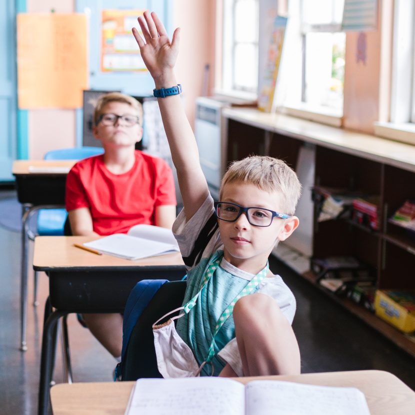 Skoleelev som rekker opp hånden