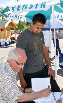 Øystein Smidt signerer jubileumsboka for Abid Raja under Årnesdagene