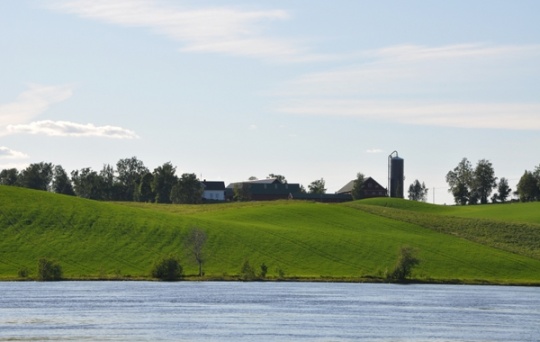 Gård og åker langs Glommas bredder