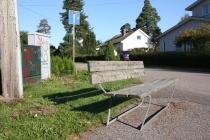 Parkbenk ved siden av vegen i krysset ved en blindvei og kobblingsbokser med tagging på